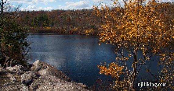 Terrace Pond surrounded by a rocky shore and yellow foliage.