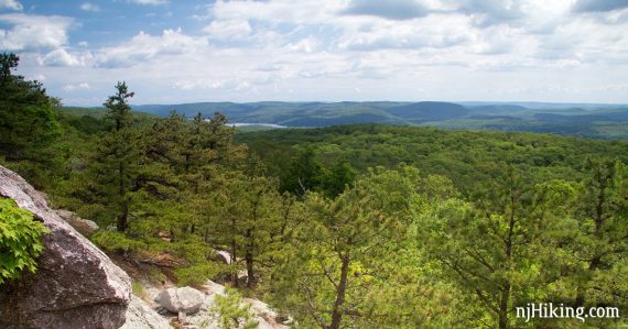 View of rolling green hills from a rocky outcropping.