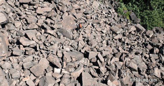 Hiker negotiating a vast rock scramble.