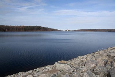 Bright blue reservoir near a stone wall