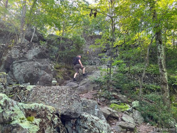 Hiker climbing a very rocky incline.