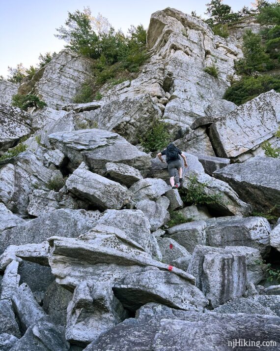 Hiker navigating a vertical rock scramble.