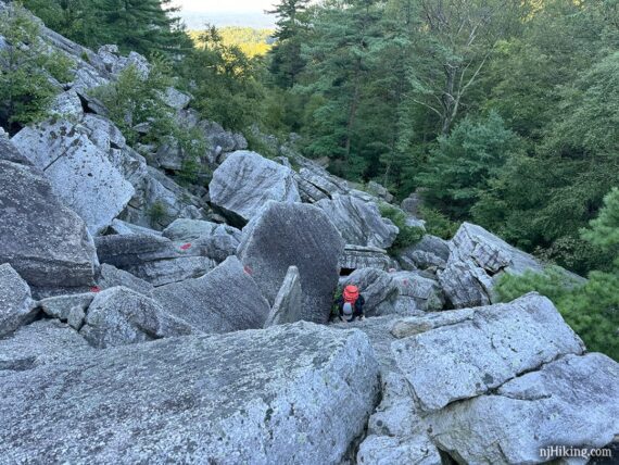 Looking down at a hiker climbing Bonticou Crag.