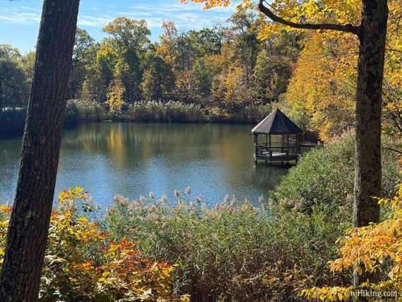 Gazebo on a pond surrounded by fall foliage.